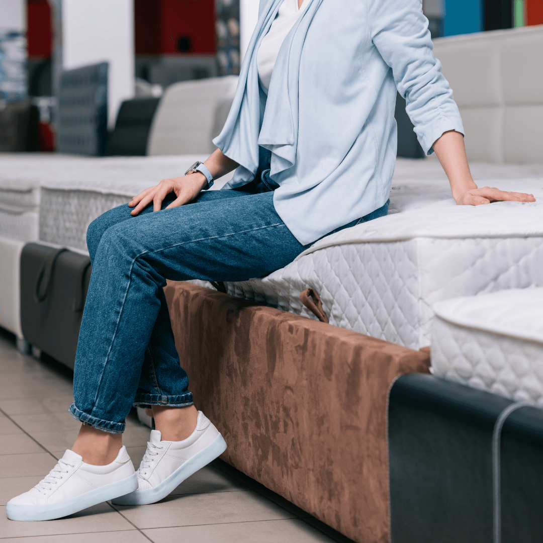 woman sitting on a bed in a bed shop